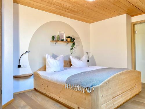 a bedroom with a bed with a wooden headboard at Best Butler Alp Villa 11 Personen I Blockhütte I Parken I Lagerfeuer I Netflix in Hopferau