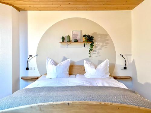 a bedroom with a large bed with white pillows at Best Butler Alp Villa 11 Personen I Blockhütte I Parken I Lagerfeuer I Netflix in Hopferau