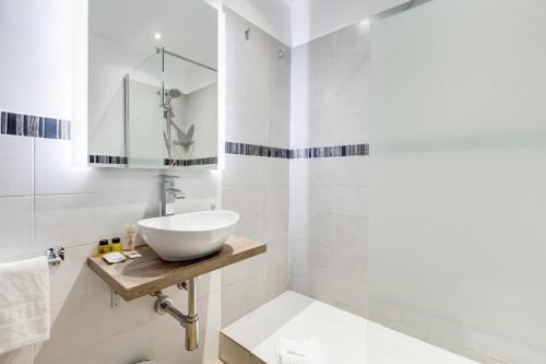 a white bathroom with a sink and a mirror at Vatican Prestige Apt by Premium Suites Collection in Rome