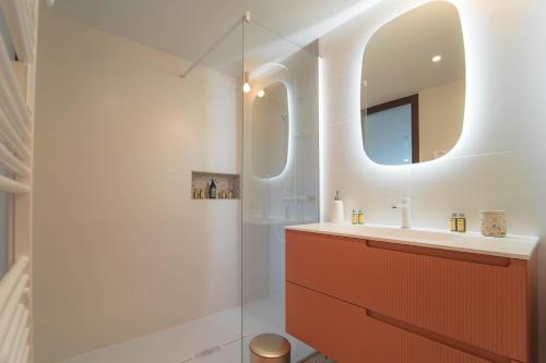 La salle de bains est pourvue d'un lavabo et d'un miroir. dans l'établissement Villa Ananda - Chandra - Un havre de paix entre mer et étangs, à Carnon-Plage