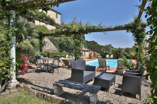 un patio con sillas, una mesa y una piscina en Fattoria di Cinciano en Poggibonsi