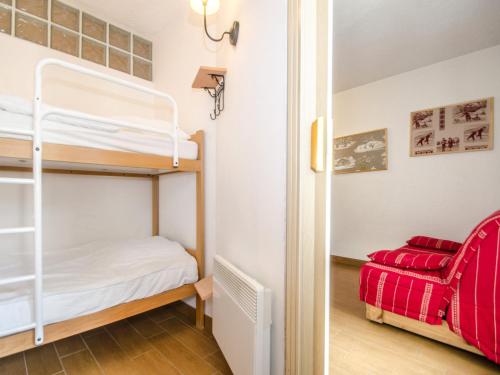 - une chambre avec des lits superposés et un fauteuil rouge dans l'établissement Studio cosy à Chamonix Sud, proche centre, balcon, 4 pers, parking, WiFi - FR-1-343-235, à Chamonix-Mont-Blanc