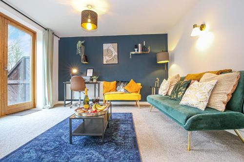 a living room with a green couch and a table at Beautiful City Centre Apartment with Free Parking, Fast-Wifi, SmartTV with Netflix and Private Garden by Yoko Property in Milton Keynes
