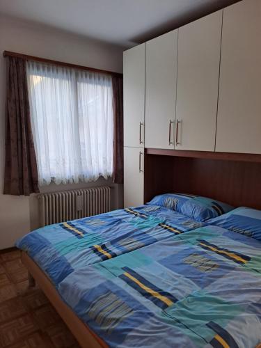 Schlafzimmer mit einem großen Bett mit blauer Decke in der Unterkunft Casa Di Vacanza Cevio in Cevio