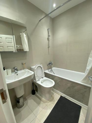 a bathroom with a sink and a toilet and a bath tub at 4 Wharncliffe Drive in Hanwell