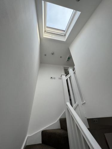 a room with stairs and a skylight in the ceiling at 4 Wharncliffe Drive in Hanwell
