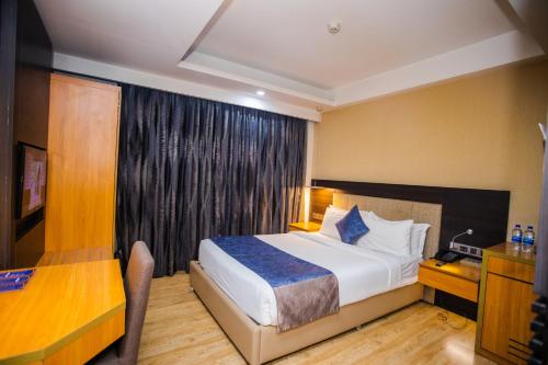 Cette chambre comprend un lit et un bureau. dans l'établissement Days Hotel Dhaka, à Dhaka