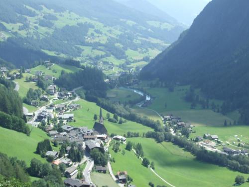 a small village in a green valley with a river at Ferienwohnung Hohe Wand in Heiligenblut