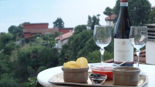 a table with a bottle of wine and two glasses at B&B Casa Forster in Cannero Riviera