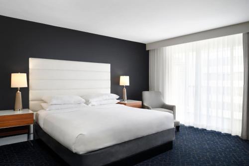a bedroom with a large white bed and a window at Hotel Tampa Riverwalk in Tampa