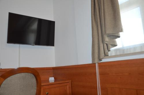 een flatscreen-tv aan een muur naast een raam bij Isolabella in Foce Varano