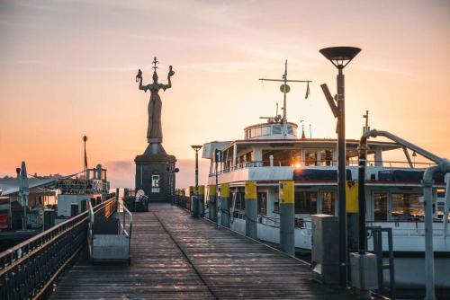 a boat on a dock with a statue in the background at FeWo Michaela Köst in Konstanz