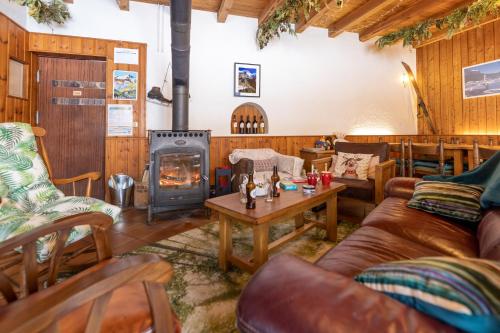 sala de estar con chimenea, sofá y estufa de leña en REFUGE- GITE Le Pas de l'Ane en Villar-dʼArène