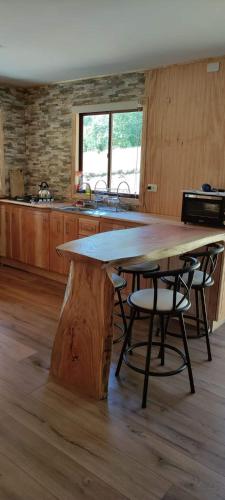 una gran mesa de madera en una cocina con una mesa de madera en Cabañas Mañio Melipeuco en Melipeuco