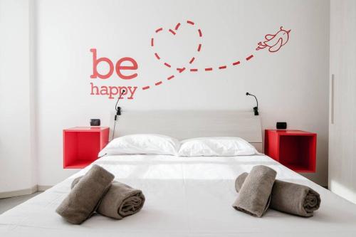 a bedroom with a bed with a be happy sign on it at Be Happy - The House Of Travelers in Como
