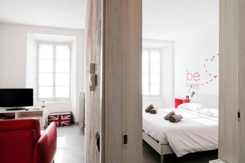 a bedroom with a bed and a desk with a television at Be Happy - The House Of Travelers in Como