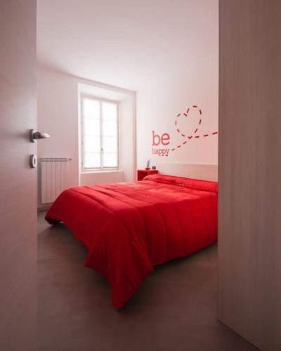 a bedroom with a red bed with a heart on the wall at Be Happy - The House Of Travelers in Como