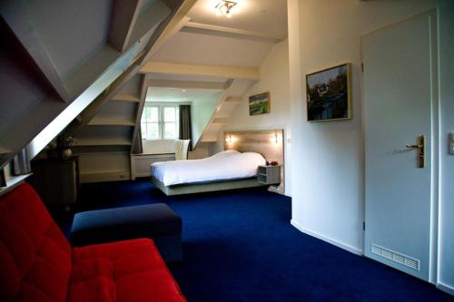 een slaapkamer met een bed en een trap bij Hotel-Restaurant Het Rechthuis in Muiderberg