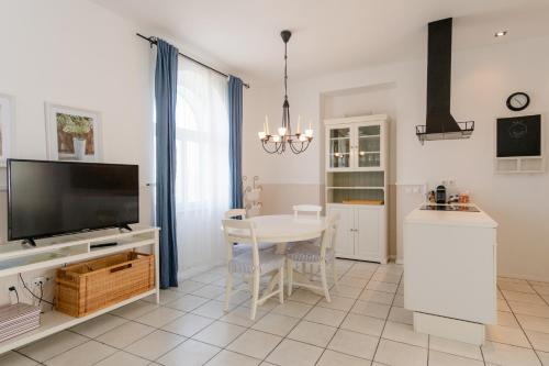 eine Küche und ein Esszimmer mit einem Tisch und einem TV in der Unterkunft Pavi apartments Vila Amalia in Šilo