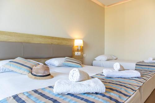a hotel room with two beds with towels and a hat at Theo Star Beach Hotel in Malia