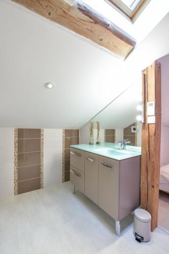 - une salle de bains mansardée pourvue d'un lavabo dans l'établissement L’olivier, à Montmerle Sur Saône