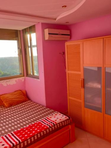ein kleines Schlafzimmer mit einem Bett und einem Fenster in der Unterkunft Appartement wifaq in Temara