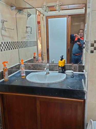 a man taking a picture of a sink in a bathroom at Appartement wifaq in Temara