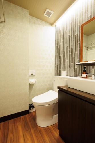 a bathroom with a toilet and a sink and a mirror at Hotaku HOTEL Akihabara in Tokyo