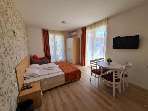 Habitación de hotel con cama y mesa con mesa en MIDA Apartment, en Obzor