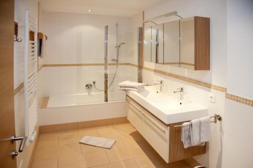 a bathroom with a sink and a tub and a shower at Filzenhof in Kitzbühel