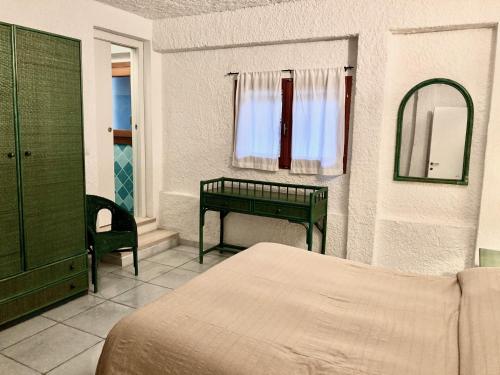 a bedroom with a bed and a mirror and a table at Villa Angela in Santa Teresa Gallura