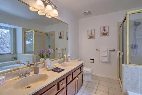 a bathroom with two sinks and a large mirror at Family-Friendly Aurora Vacation Rental with Yard! in Aurora