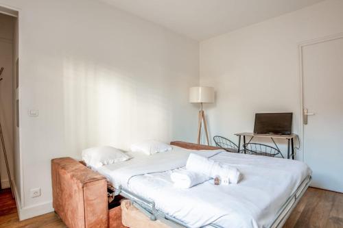 - une chambre avec 2 lits et une table avec un ordinateur portable dans l'établissement Appartement Ocre - Welkeys, à Bagnolet