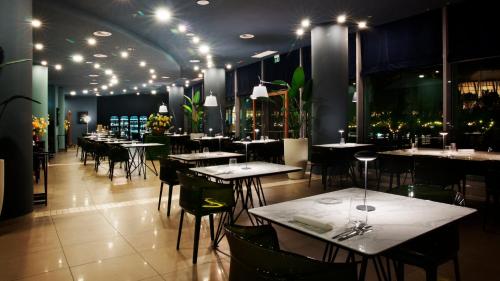 a dining room with tables and chairs and lights at Holiday Inn Nola - Naples Vulcano Buono by IHG in Nola