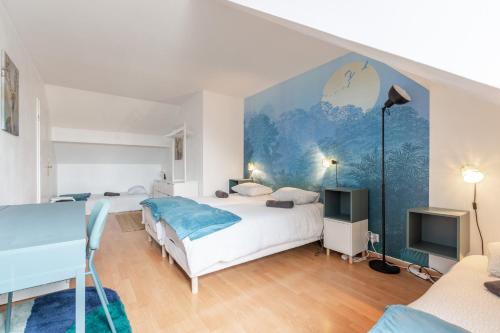 a bedroom with two beds and a blue wall at Duplex Chancelier - Fairytale Factory in Bussy-Saint-Georges