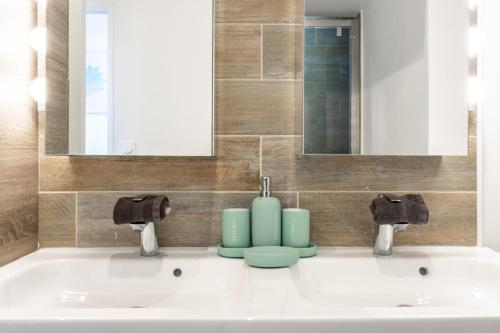 a bathroom with two sinks and two faucets at Duplex Chancelier - Fairytale Factory in Bussy-Saint-Georges