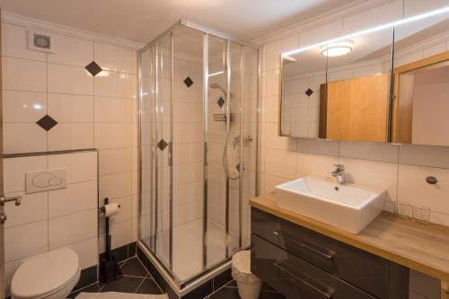 a bathroom with a shower and a sink and a toilet at Gästehaus Ingeborg in Saalbach Hinterglemm