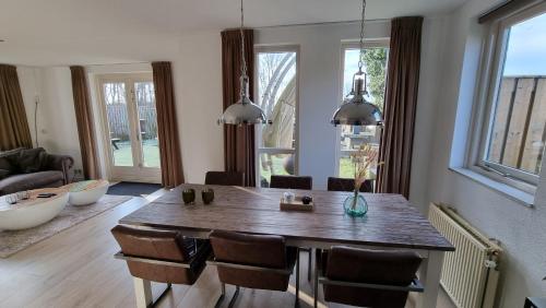 sala de estar con mesa de madera y sillas en Recreatiewoning Maas en Waal 191, en Ewijk