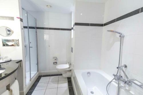a bathroom with a tub and a toilet and a sink at Crowne Plaza Brussels Airport by IHG in Zaventem