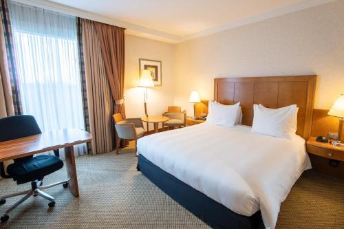 a hotel room with a large bed and a desk at Crowne Plaza Brussels Airport by IHG in Zaventem