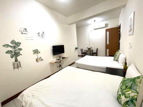 a hotel room with two beds and a tv at 二街窩窩電梯民宿花蓮車站東出口Second street Nest Hostal in Hualien City