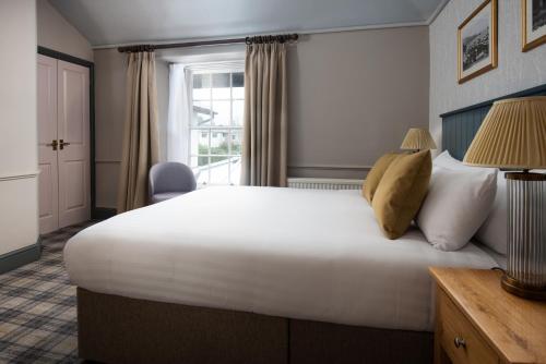 a bedroom with a large white bed and a window at The Angel Inn - The Inn Collection Group in Bowness-on-Windermere