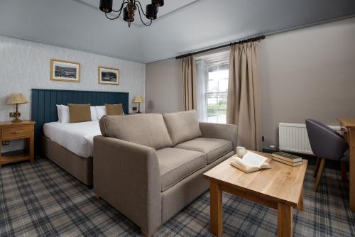 a hotel room with a bed and a couch at The Angel Inn - The Inn Collection Group in Bowness-on-Windermere