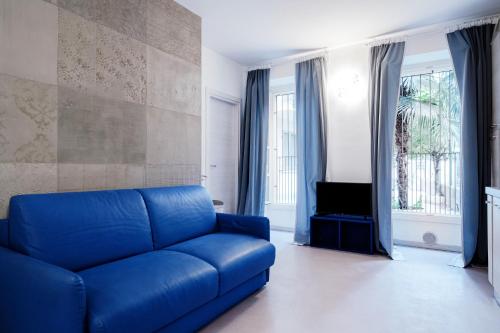 a blue couch in a living room with a tv at Blue Loft - The House Of Travelers in Como