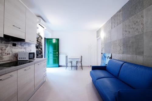 a living room with a blue couch in a kitchen at Blue Loft - The House Of Travelers in Como