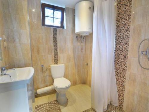 a bathroom with a toilet and a sink and a window at Domki całoroczne DOMKOWSTWO in Bóbrka