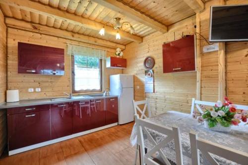 a kitchen with a dining table and a refrigerator at Domki całoroczne DOMKOWSTWO in Bóbrka