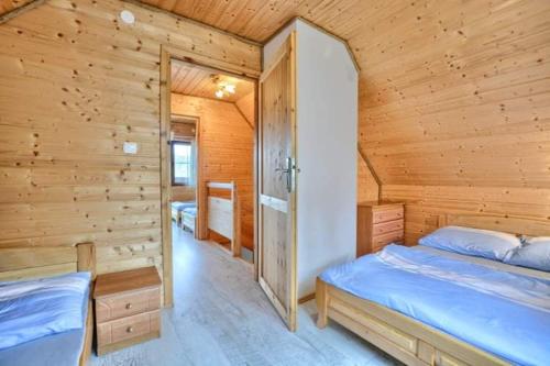 a log cabin bedroom with a bed and a closet at Domki całoroczne DOMKOWSTWO in Bóbrka