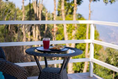 a table with a plate of food and a drink at Zostel Plus Nainital (Naina Range) in Nainital