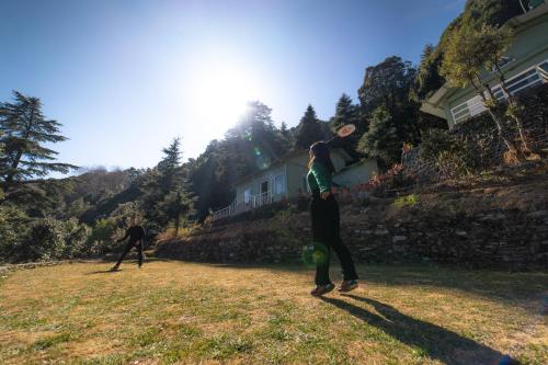 two people playing with a frisbee in a yard at Zostel Plus Nainital (Naina Range) in Nainital